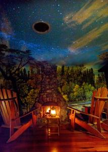 アーケータにあるThe Front Porch Hidden Oasisの石造りの暖炉と椅子2脚の絵画