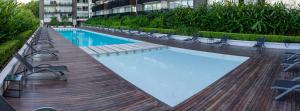 una gran piscina con sillas y un edificio en Fliphaus Amenabar 30 - Lux Loft Palermo Holly en Buenos Aires