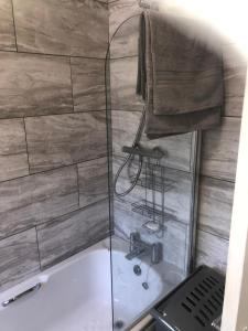 een badkamer met een douche en een bad bij Angie’s hideaway in Balby