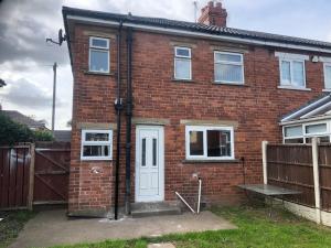 a red brick house with a white door at Angie’s hideaway in Balby