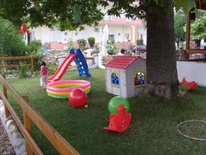 a playground with toys on the grass next to a tree at Estelle Hotel in Gerakini