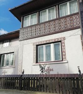 a house with a fence in front of it at Casa Agroturistică Teodora in Mănăstirea Humorului