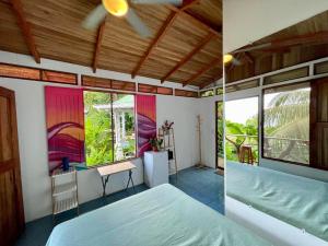 a bedroom with a bed and a room with a window at The Chorotega Arte y Sol Hotel in Montezuma