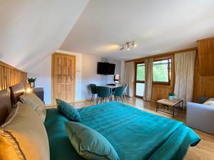 een slaapkamer met een groot bed en een woonkamer bij Domek Pod Lisem Szczawnica in Szczawnica