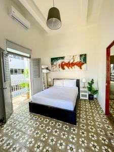 a bedroom with a large bed and a balcony at Nando's Place in San Juan