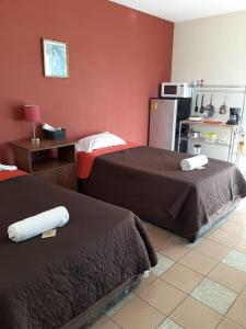 um quarto de hotel com duas camas e um frigorífico em HABITACIÓN AZALEA, BAÑO PRIVADO Y COCINETA. em Tepic