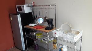uma cozinha com frigorífico e um balcão com utensílios em HABITACIÓN AZALEA, BAÑO PRIVADO Y COCINETA. em Tepic