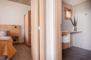 um pequeno quarto com uma cama e um espelho em Wa One Lake Homes em San Carlos de Bariloche