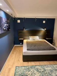 a bedroom with a bed and a blue wall at Vikran Apartments Na Końcu Świata in Vikran