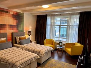 a hotel room with two beds and a chair at Amsterdam 4 Holiday GuestRooms in Amsterdam