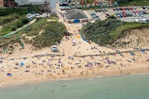 an aerial view of a crowded beach with people at 'Sunnyside' Chalet, walk to the beach & close to Norfolk broads - pet friendly! in Great Yarmouth