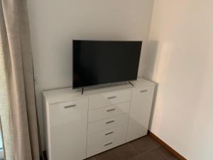 a flat screen tv on top of a white dresser at Wohlfühl-Apartment in Ettlingen