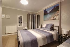 a bedroom with a bed and a large painting on the wall at The Rosslyn in Paignton