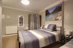 1 dormitorio con 1 cama y una gran pintura en la pared en The Rosslyn, en Paignton