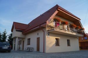 un edificio con un balcón con flores. en Villa Amber en Sarbinowo