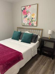 1 dormitorio con 1 cama y 1 mesa con una foto en The Irene - 2 Bedroom Apt in Quilt Town, USA, en Hamilton