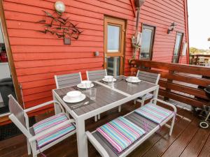 uma mesa e cadeiras no alpendre de uma casa vermelha em Beachmaster em Deal