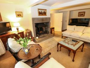 a living room with a couch and a fireplace at Woodlea Cottage in Huddersfield
