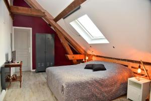a bedroom with a large bed and a skylight at Les Colombines in Hombleux