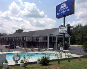 a hotel with a swimming pool in front of a building at Americas Best Value Inn-Winnsboro in Winnsboro