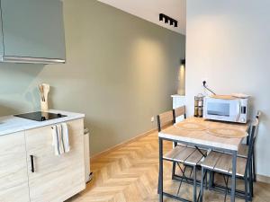 uma pequena cozinha com uma mesa e um micro-ondas em Le Flachet - Climatisation - Wifi em Villeurbanne