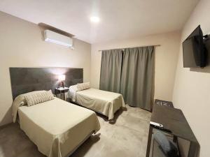 a hospital room with two beds and a television at Tres Cruces in Villa Unión