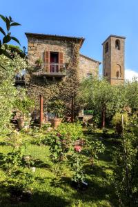 Edificio de piedra antiguo con balcón y torre en Corte della Maestà Antica Residenza, en Bagnoregio