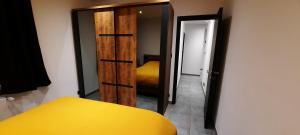 a bedroom with a yellow bed and a sliding door at Nez sur la croisette. in Dinant