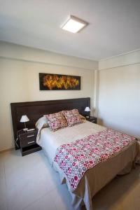 una camera con un grande letto e due comodini di Best Parque - Pileta y Cochera - Solo autos a San Miguel de Tucumán
