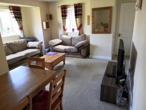 a living room with a couch and a table at Lovely Cosy Apartment near Water Parks in South Cerney