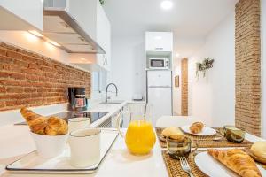 una cocina con una mesa con pan y zumo de naranja en CARTAGENAFLATS, Apartamentos San Francisco, en Cartagena