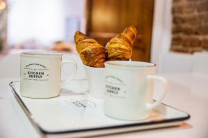 two cups of croissants and a laptop on a table at CARTAGENAFLATS, Apartamentos San Francisco in Cartagena
