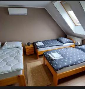 Habitación con 3 camas en un ático en Fáraó vendégház, en Zalaegerszeg