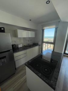 a kitchen with a counter top with a stove top oven at Marmol y Constitución, con vista al mar in Mar del Plata