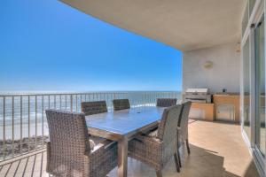 a dining room with a table and chairs and the ocean at Turquoise C702 in Orange Beach