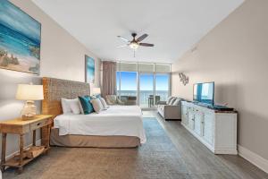 a bedroom with a bed and a television in it at Turquoise C702 in Orange Beach