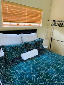 1 dormitorio con 1 cama con edredón azul y blanco en Q’s, en Empangeni