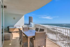 a balcony with a table and chairs and the ocean at Turquoise C702 in Orange Beach