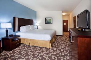 a hotel room with a bed and a flat screen tv at Holiday Inn Express Hotel & Suites Atlanta Airport West - Camp Creek, an IHG Hotel in Atlanta