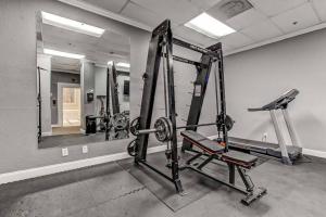 a gym with several tread machines and a mirror at Cozy Downtown One Bedroom Condo Jacksonville in Jacksonville
