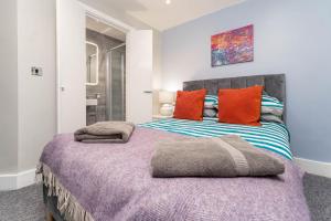 a bedroom with a large bed with orange and blue pillows at Sealanes 2 in Brighton & Hove