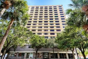 a tall building with palm trees in front of it at Cozy Downtown One Bedroom Condo Jacksonville in Jacksonville