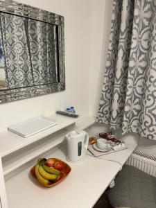 a bowl of fruit on a table in a kitchen at TJ Homes - One double bed room with garden view - Next to tube station in Ruislip