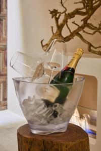 - Uma taça de vidro com 2 taças de vinho e uma garrafa de champanhe; em One Suite em San Marino