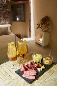 einen Tisch mit zwei Gläsern Saft und Essen drauf in der Unterkunft One Suite in San Marino