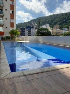 una gran piscina en la parte superior de un edificio en Apartamento Guarujá Lazer completo Villa Di Fiori 600mts da praia, en Guarujá