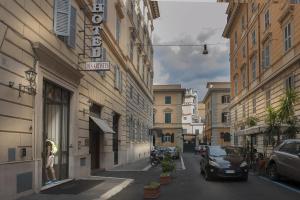a city street with cars parked on the side of buildings at Hotel Des Artistes in Rome