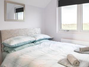 a bedroom with a white bed with a mirror on the wall at Appaloosa Suite - Uk41831 in Tickton