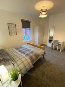 A spacious & modern 3-bed home في بلاكبيرن: غرفة نوم بسرير وطاولة وكراسي