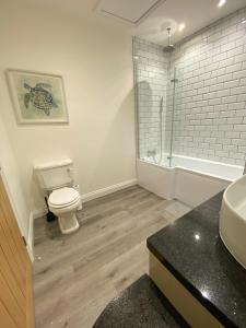 a bathroom with a toilet and a sink and a shower at A spacious & modern 3-bed home in Blackburn